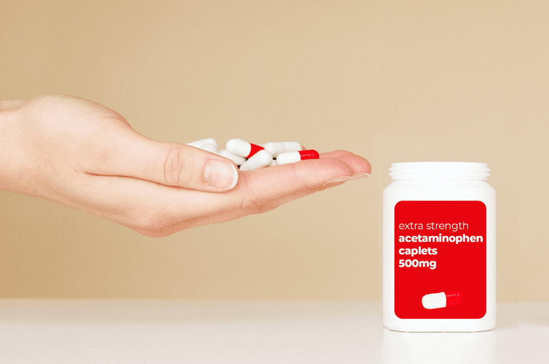 Hand with acetaminophen pills and bottle beside it