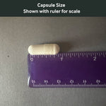 Dr. Murray's Ultra Clean Magnesium Glycinate capsule size shown with a ruler for scale on a gray background