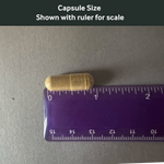 Dr. Murray's Ultimate Metabolic capsule size shown with a ruler for scale on a gray background