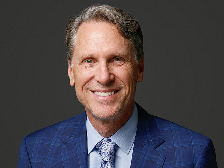 Dr. Murray wearing a blue checkered suit with a gray background