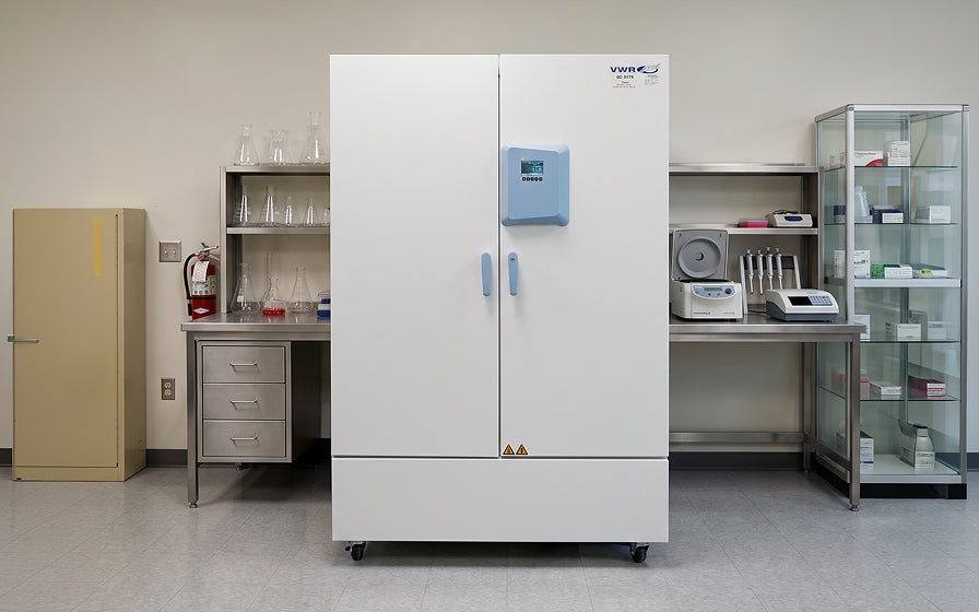 Large white refrigerator in a laboratory setting with various equipment.