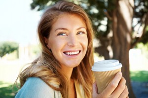 happy-woman-drinking-coffee-outdoors-horiz